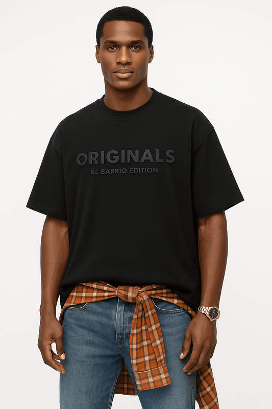 EL Barrio Originals Men's Oversize t-shirt in black with 3D 'ORIGINALS' text, styled with jeans and plaid shirt for streetwear appeal.