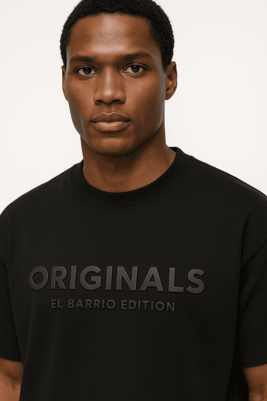 Close-up of EL Barrio Originals Men's Oversize t-shirt showcasing bold 3D 'ORIGINALS EL BARRIO EDITION' graphic on organic cotton fabric.