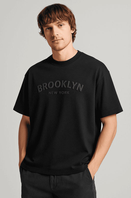 Brooklyn NYC T-Shirt - Men's Oversize in black organic cotton with 3D graphic text, styled for casual streetwear comfort and relaxed fit.