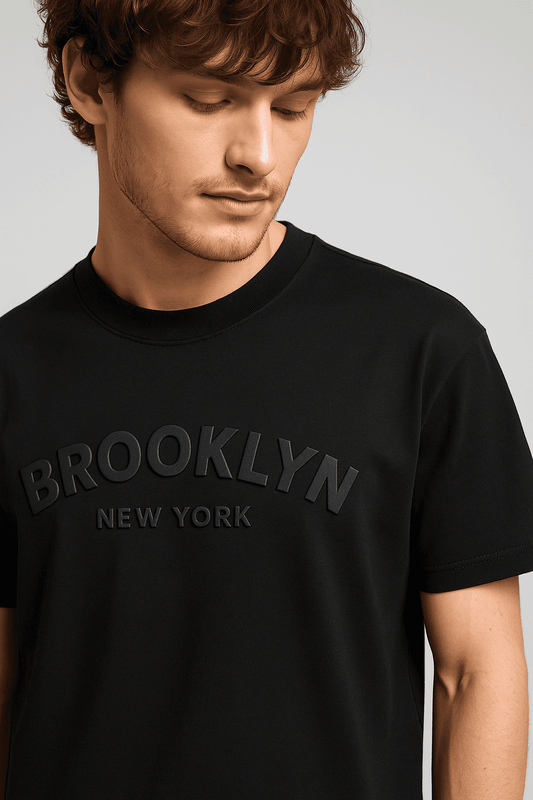Close-up of Brooklyn NYC T-Shirt - Men's Oversize showing embossed 3D graphic on soft black organic cotton fabric for a bold streetwear look.