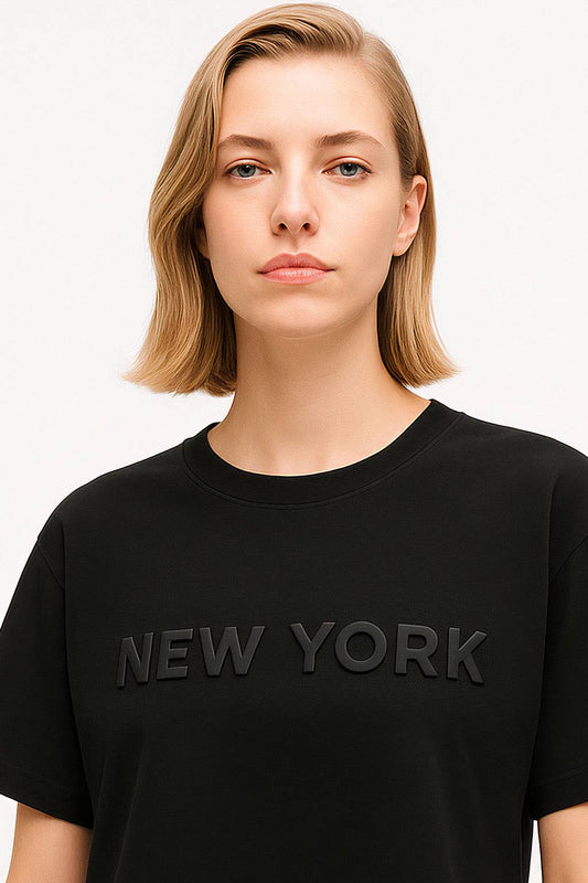 Close-up of New York Crop Top - Women's NYC Crop Tee featuring raised 'NEW YORK' text on soft black cotton for a sleek urban look.