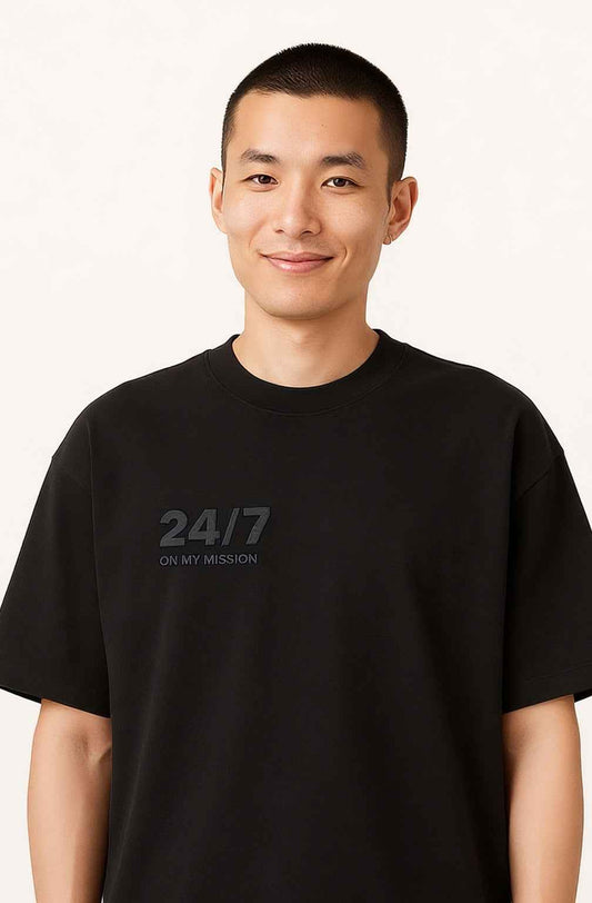 Front view of 24/7 ON MY MISSION - Men's Streetwear T-Shirt in black with minimalist 3D embossed text on chest. Organic cotton oversized fit.