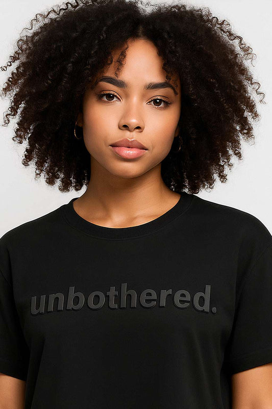 Close-up of Unbothered Crop Top - Women’s Crop Tee showing soft cotton fabric and embossed 'unbothered.' text for a minimalist vibe.