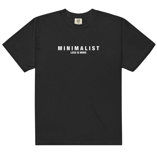 Flat lay of black Minimalist Graphic T-Shirt featuring bold white 'MINIMALIST Less Is More' text, ideal for capsule wardrobes and minimalist fashion.