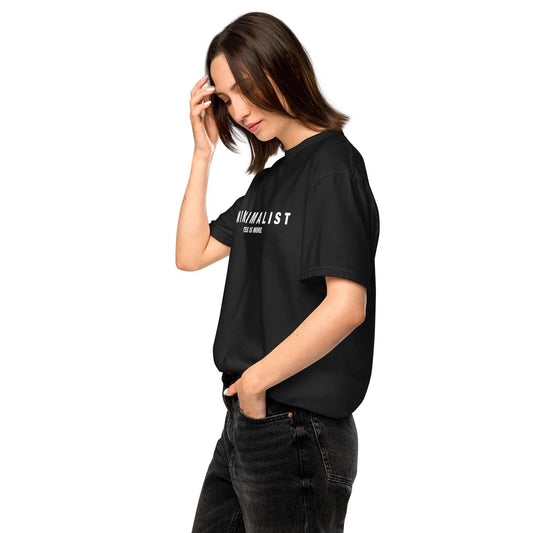 Minimalist Graphic T-Shirt in black with 'MINIMALIST Less Is More' slogan, styled casually with dark jeans for a modern neutral fashion look.
